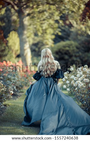 Princess with blond hair running away in blooming garden