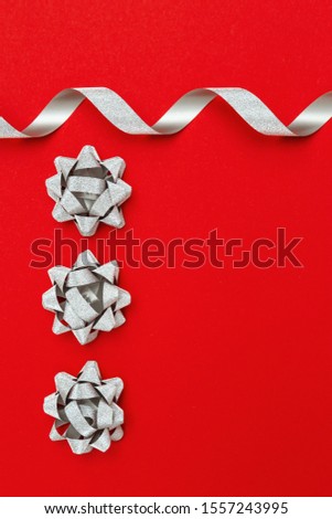 Minimal composition background of silver ribbon and bow. Christmas decor. New Year concept.Â 