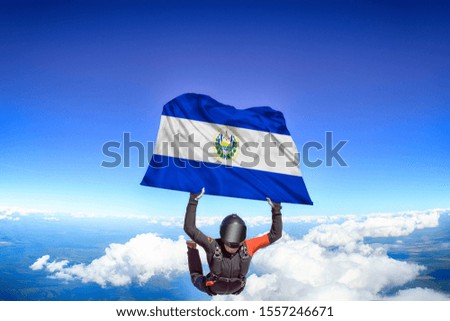 Salvador flag. Flag in skydiving. People in free fall grab flag of Saudi Arabia. Patriotism, men and flag.
