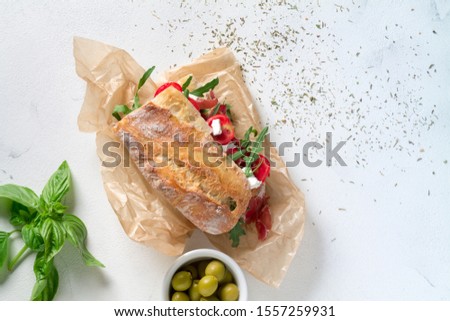 Sandwich with jamon, cheese, tomatoes and arugula on a white background. top view