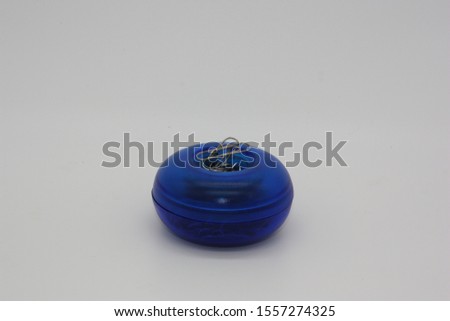 Close up of blue paper clip dispenser on white background