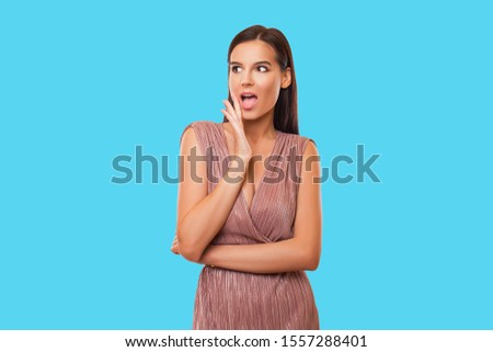 Close up Photo of impressed Lady showing Recommendation scream unbelievable wearing peach striped dress isolated over blue Background. Beautiful ad brunette Girl and perfect make up. Isolated.        