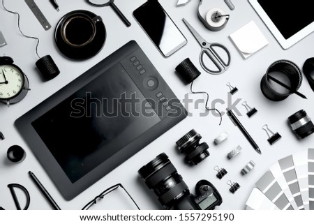 Flat lay composition with graphic drawing tablet and different office items on light background. Designer's workplace