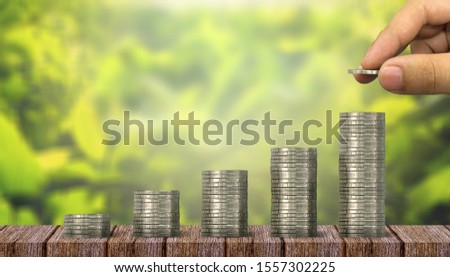 Concepts of saving money and investing, The hands of investors holding coins placed on gold coins at a level different from financial .