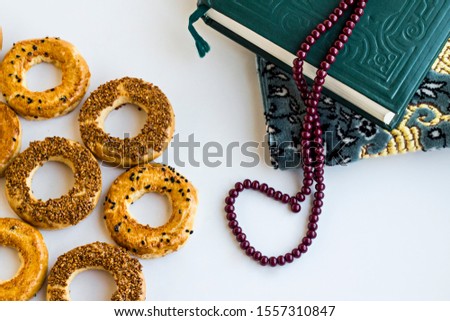 Traditional Turkish Sesame Rings Kandil Simidi on the white surface with holy book and rosary.Usually cooked on holy nights in Islam culture.