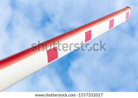 Arm barrier against the blue sky. Symbol of prohibition or permission to trade. Embargo. Entrance somewhere. Close-up