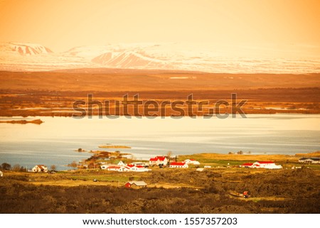 View to the small town and snowy mountains in the Iceland. Toned.