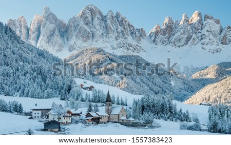 The small village Val di Funes covered in snow, with Dolomites mountains, South Tyrol, Italy. Royalty-Free Stock Photo #1557383423