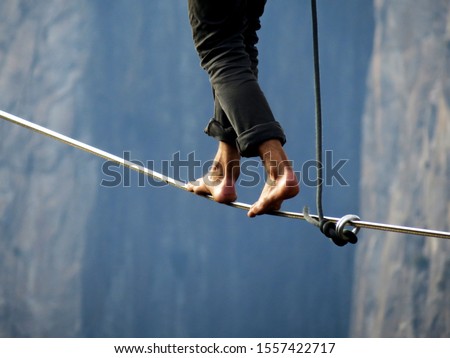  Tight rope highline walker over a high cliff                                Royalty-Free Stock Photo #1557422717