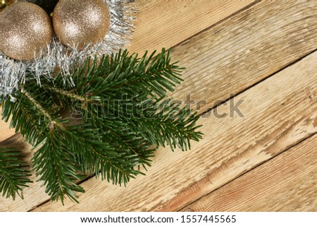 New Year's composition, Christmas decorations. Two color Christmas balls lie on fir branches next to silver Christmas tinsel on a wooden background with copy-space