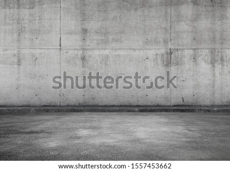 Empty parking lot, interior background with gray concrete wall and asphalt flooring, abstract photo texture