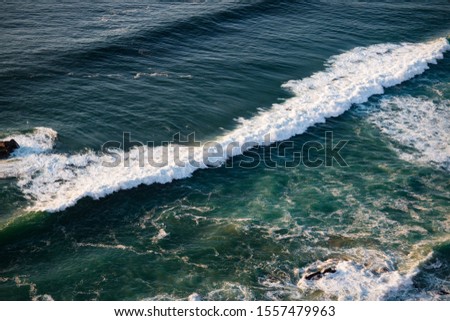 Waves and rocks in rays of setting sun on Cabo da Roca, Portugal.