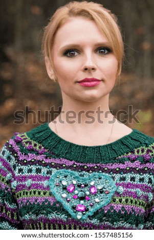 
Portrait of a young woman in a hand-knitted sweater with a heart