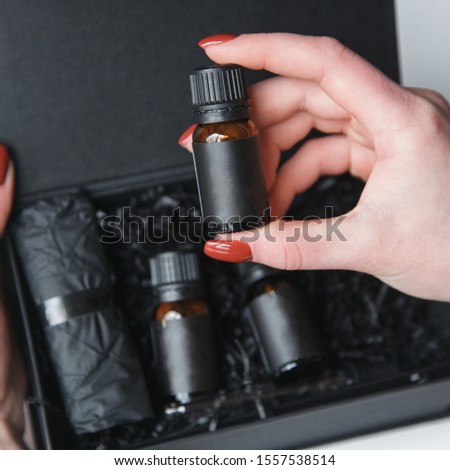  Hands with a set of cosmetics. Jars and tube for makeup on a white background.