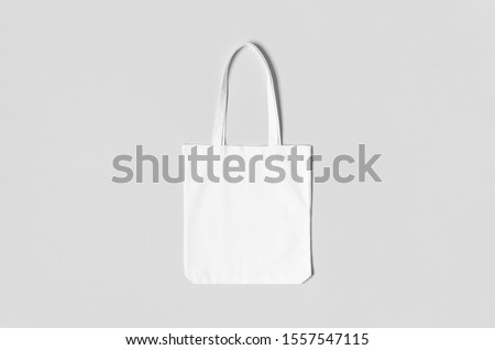 White tote bag mockup on a grey background. Royalty-Free Stock Photo #1557547115