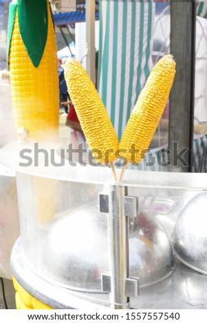 Popcorn machine during food festival, street food or carnival event. Sweet corn or kernel boiling machine outdoor setting. Yellow fresh kernels preparation or cooking