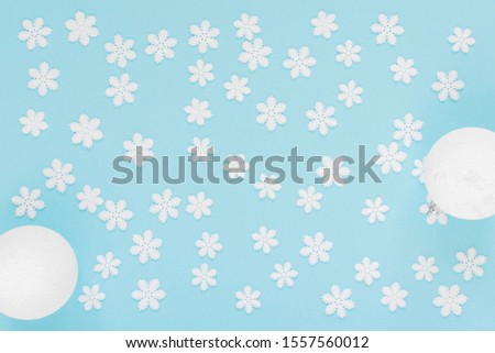 Holiday pastel background, white snowflakes and Christmas ball on a gentle blue background ,flat lay, top view