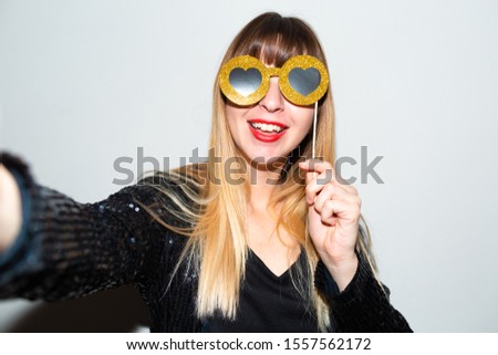Image of brunette smiling woman in toy sunglasses while taking selfie photo isolated over grey wall