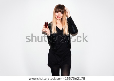 Image of cute joyful woman holding glass of champagne while taking selfie photo isolated over grey wall