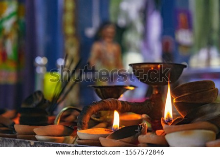 Burning old textured candles with defocussed background of the most popular Hindu shrines outside India - Batu Caves. Mood of sacrament and revelation. Soft focus