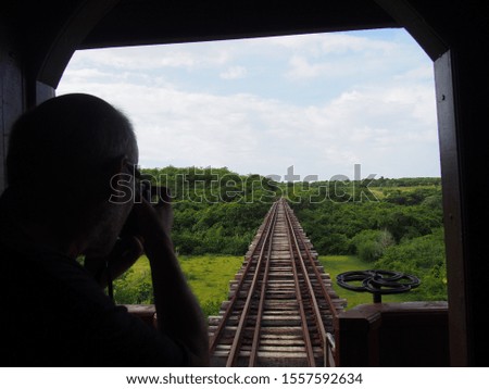 A man taking pictures with his camera from inside a running train, Trinidad, Cuba