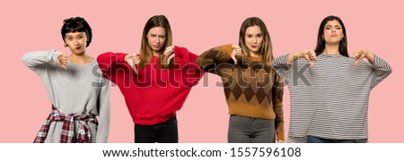 Set of women over isolated pink background showing thumb down