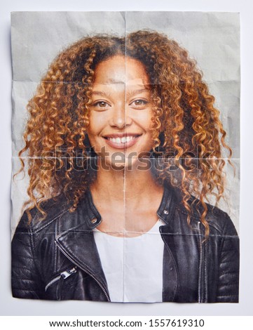 Mental Health Concept With Creased Picture Of Smiling Woman In Studio