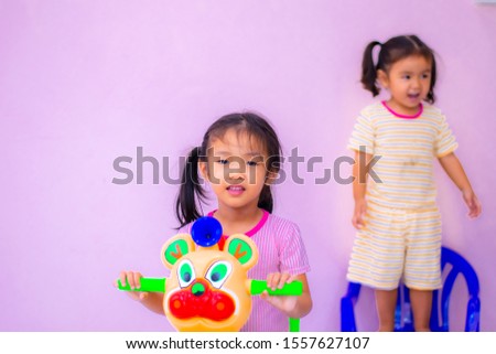 an Asian gir Kindergarten girl playing tricycle