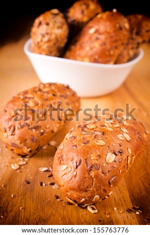 Whole grain small bread on the wooden table. Selective focus on the front bread