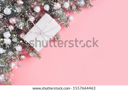 Christmas pastel composition with white gift on pink background. Xmas frame with space for text. View from above. Flat lay style.
