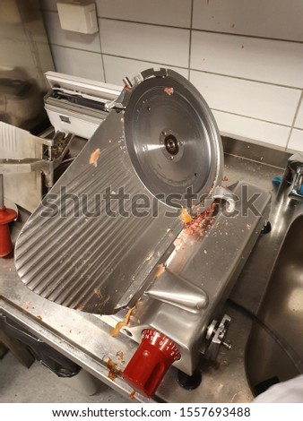 Italian meat slicer ready for cleaning after cutting ham and sausage. professional kitchen environment. Royalty-Free Stock Photo #1557693488