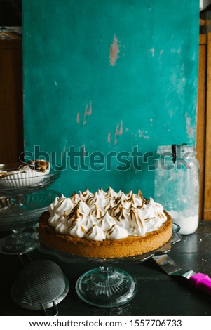 Lemon tart with french meringue caramelized on top, on a rustic table, french meringue caramelized with a food torch.