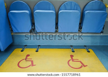 Handicap seats with red logo for disabled people or wheelchair and priority seating in a public bus