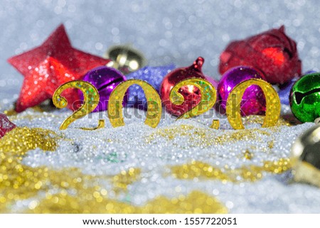 Holiday background with golden Christmas decorations and New year 2020 numbers and confetti stars top view