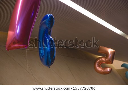Colorful balloons in the shape of a number hanging from the ceiling.