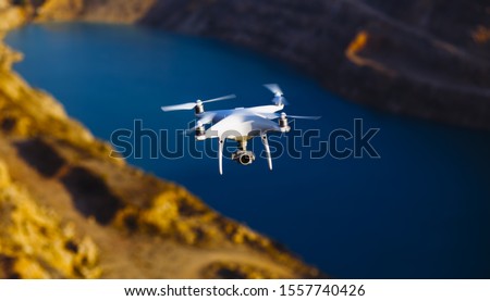 Uav drone copter flying with digital camera above opencast mining quarry. Royalty-Free Stock Photo #1557740426