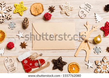 Top view of envelope on festive wooden background. Christmas toys and decorations. New Year time concept.