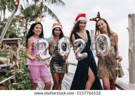 Beautiful women Holding Silver 2020 Balloons celebrating Christmas
