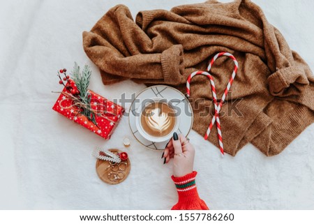 Female hands hold latte coffee cup, christmas concept, trendy instagram image. Flat lay, top view