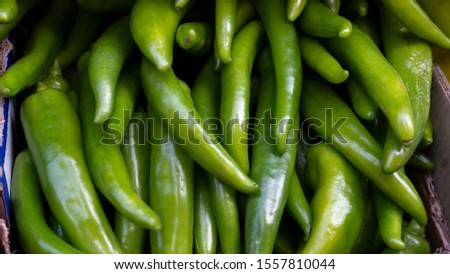 Close-up of green peppers at a street shop counter. Background, texture.