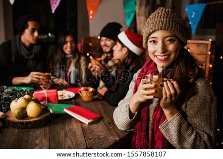 Mexican Woman drinking Ponche Navideño celebrating a Posada in Christmas Mexico