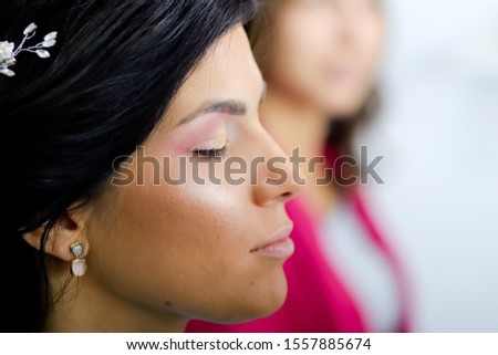 side portrait, close up of beautiful calm young woman with black hair and closed eyes, blurred girl in background, studio shot, professional make up 