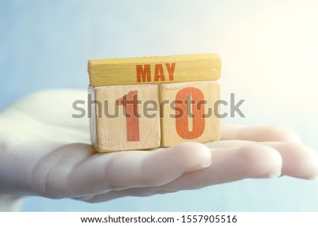may 10th. Day 10 of month,Handmade wood cube with date month and day on female palm spring month, day of the year concept