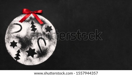 Christmas celebration. Conceptual decoration ball with pictures of stars, tree and candies on black background with copy space