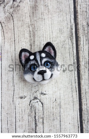 Needle felted husky brooch with the background of Globe Thistle, old grey wood and wicker white wreath. Handmade woodland animal jewelry. Wool Siberian Husky