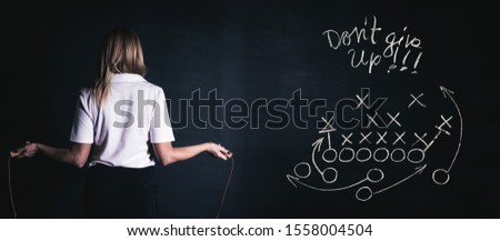 Back view of blonde woman jumping with skipping rope in gym. Fitness concept. Healthy lifestyle. Background black, billboard image.