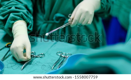Nurse holding the surgical instrument with cotton swab or peanut.