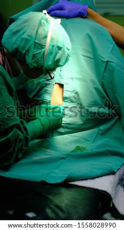 Anaesthetist performing Spinal Anaesthesia while patient sitting upright under aseptic precaution.