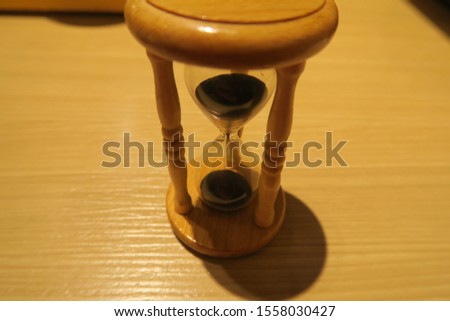 Time with hourglass on wood table