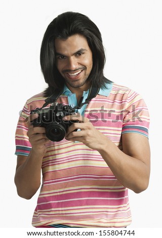 Photographer using a digital camera and smiling